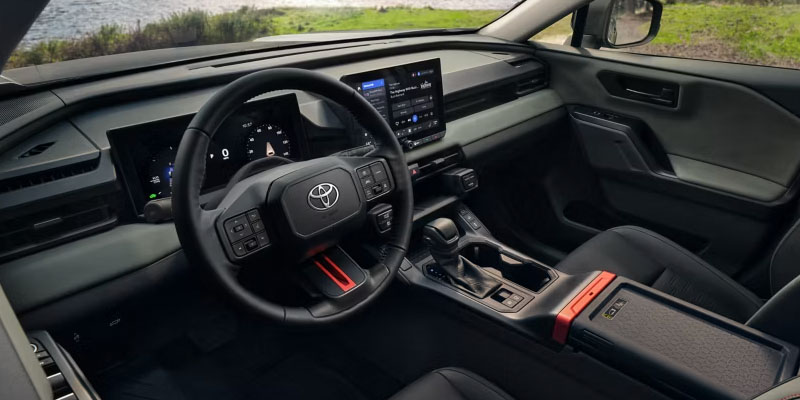 Interior of a Toyota SUV showing a modern dashboard with digital displays, a steering wheel, and a sleek center console