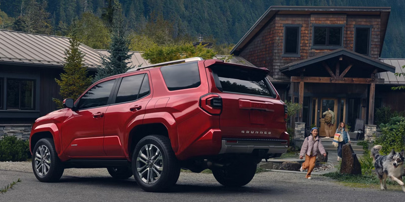 2025 Toyota 4Runner parked in front of mountain cabin with children and dog nearby
