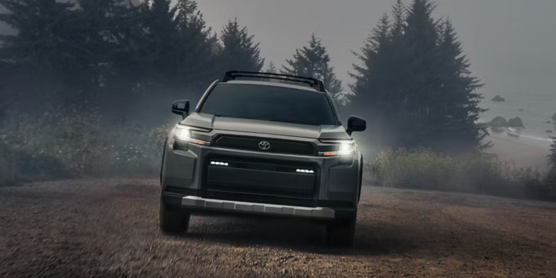 Gray Toyota SUV driving through a misty forest trail.