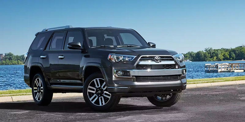 Black Toyota 4Runner SUV parked beside a lake.
